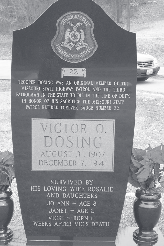 Black granite memorial headstone engraved with Victor Dosing's name, dates August 31, 1902 to December 7, 1941, and family tribute.