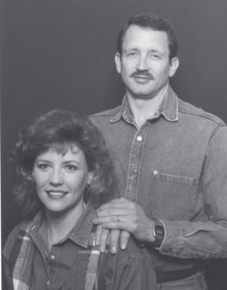 Sgt. Guilliams and a woman pose together for a black-and-white studio portrait.