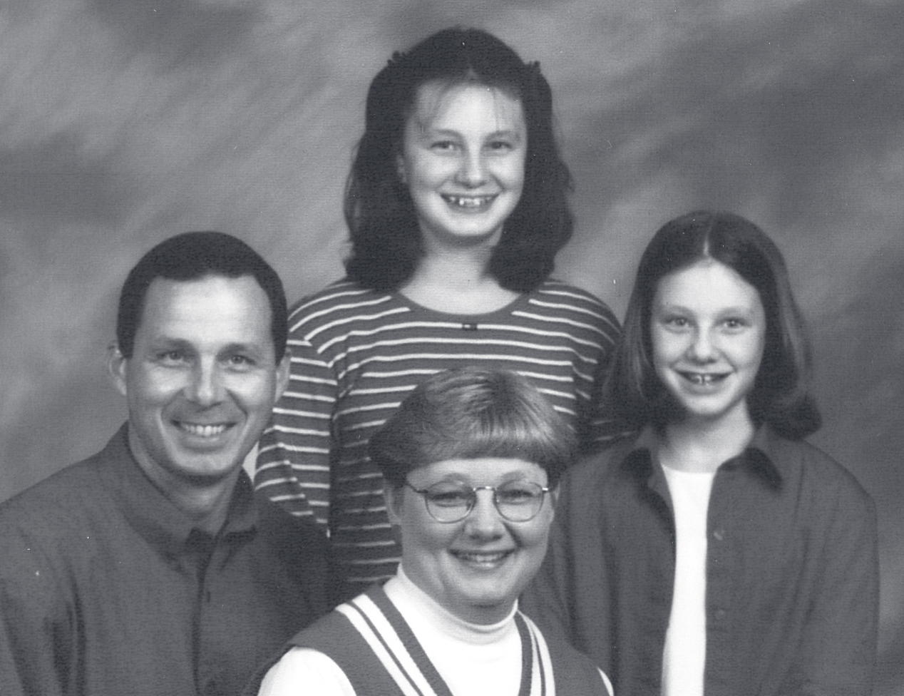 Sgt. Kimberling poses with three family members in a black-and-white studio portrait.
