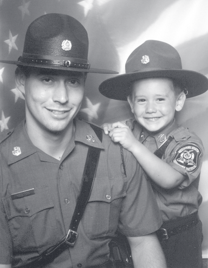 Tpr. Newton in Patrol uniform and campaign hat posing with a young boy wearing a matching hat.