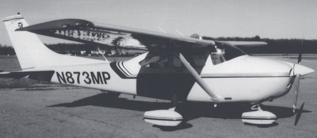 Black-and-white photograph of a single-engine Cessna aircraft with tail number N873MP parked on a tarmac.