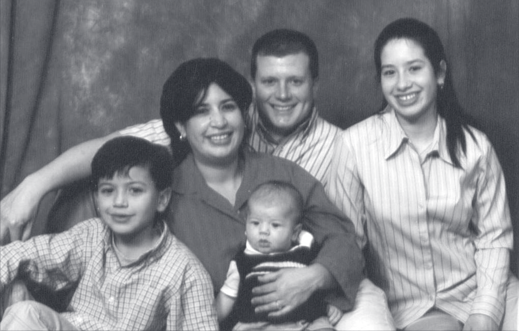 Tpr. Tatoian poses with a woman and three children for a family portrait.
